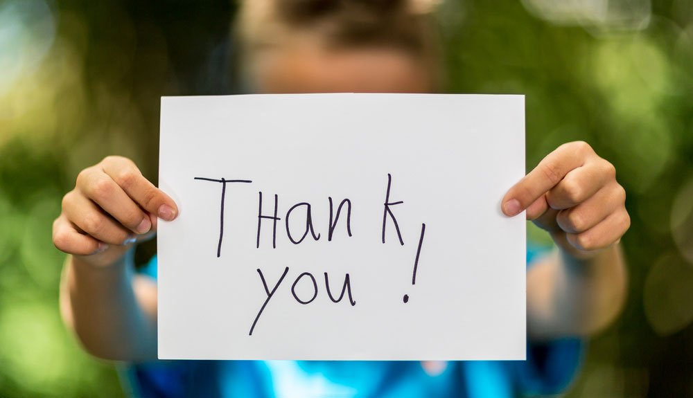 child holding a thank you sign 3